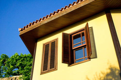 a picture of wooden Window Shutters installed on a traditional house